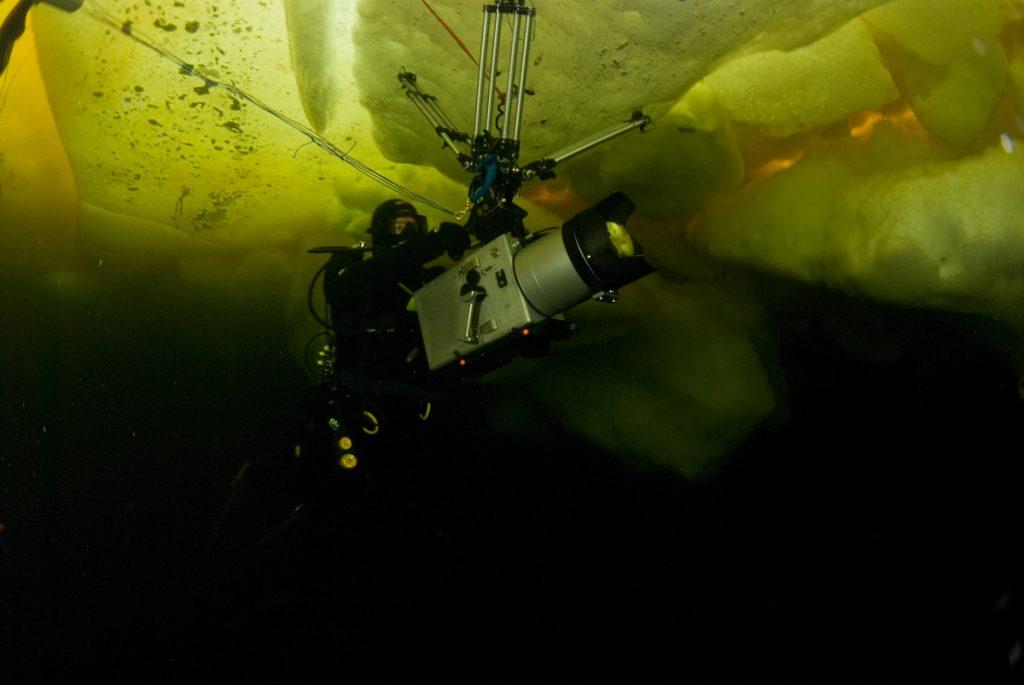 Doug Anderson films under Ice formations with tripod screwed into underside of the Sea Ice. BBC Netflix Apple TV Wildlife Filming Filmmaking Underwater Natural History Ocean Cinematography Gates  Housings Nauticam REvo Rebreathers SCUBA Finistare clothing