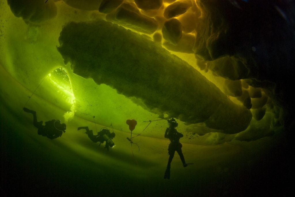 Doug Anderson and the team film under ice formations.  White Sea BBC Netflix Apple TV Wildlife Filming Filmmaking Underwater Natural History Ocean Cinematography Doug Anderson and the team film under ice formations.  Gates  Housings Nauticam REvo Rebreathers SCUBA Finistare clothing